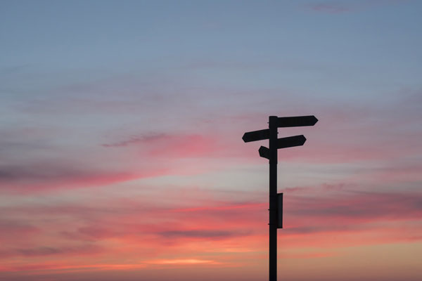 directional sign in the sunset