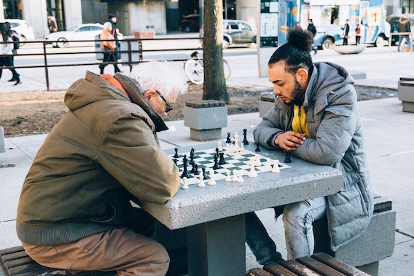 Young and old man playing chess