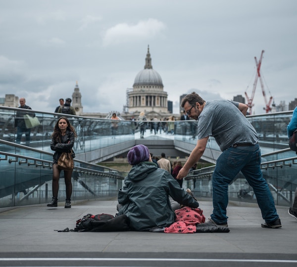 Man gives money to homeless person