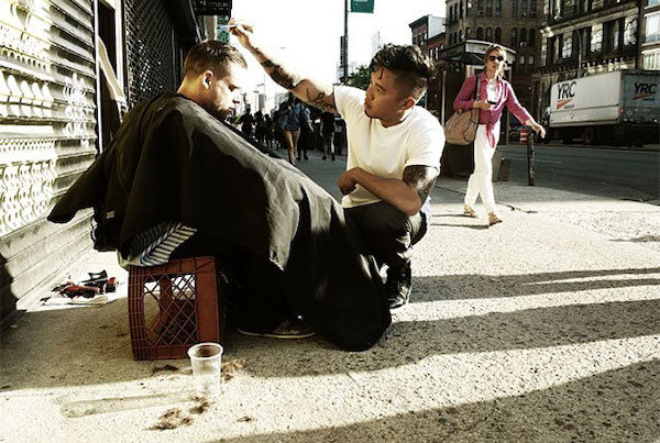 Man giving haircut to homeless person