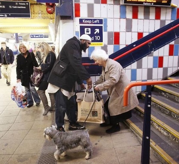 Man helps elderly woman with her bags