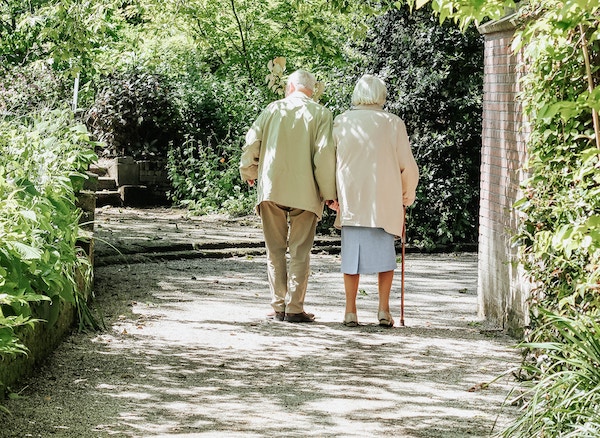 Elderly couple walking holding hands