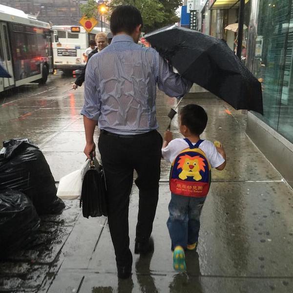 Father covering son from rain