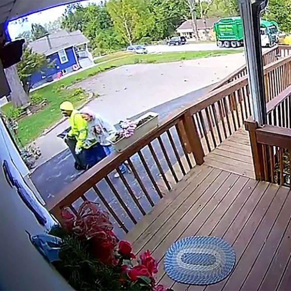 Sanitation worker helping 88-year-old woman