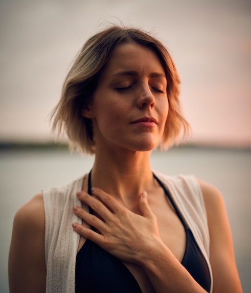 Woman Meditating With And Over Heart