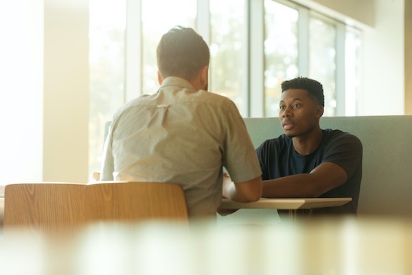 Two People Sitting at a Table Having a Conversation