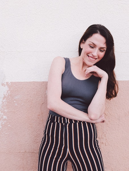 Smiling Woman Leaning Against Wall