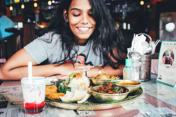 Woman Smiling Over Plate of Food