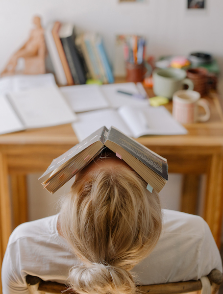 Woman Feeling Anxious With a Book Covering Her Face