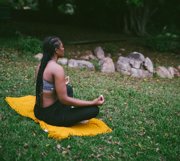 Woman Meditating on the Grass