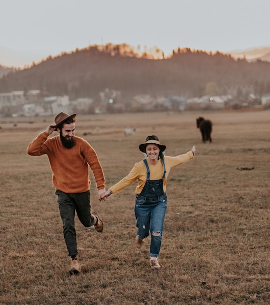 Couple Running Through Field Together