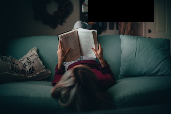 Woman Reading Book on Couch