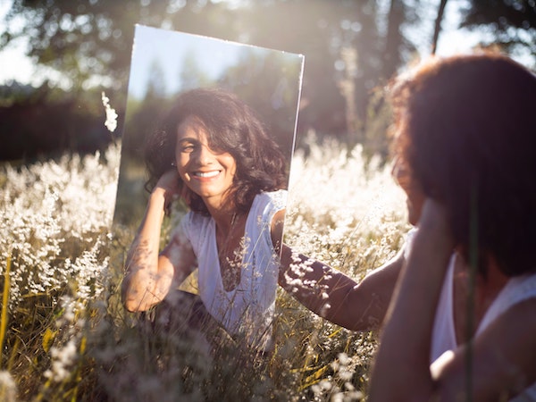 Woman Looking at Reflection in Mirror