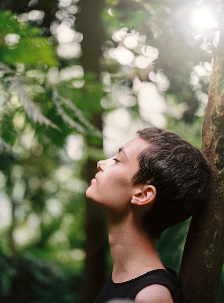 Woman Standing Next to Tree Taking Deep Inhale