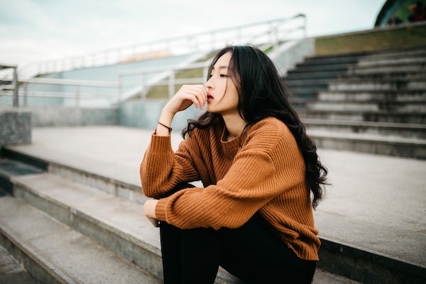 Women Sitting on Stairs Lost in Thought