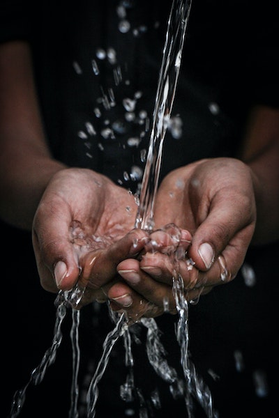 Person Holding Hands Under Running Water