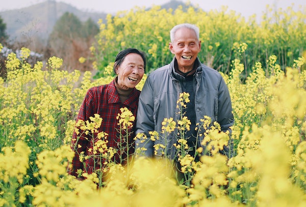 Elderly Couple Standing in Flower Field