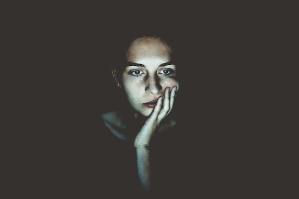 Bored Woman With Blank Stare in Dark Room
