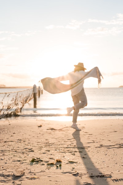 Person Joyfully Dancing on Beach