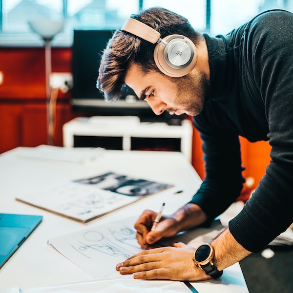 Focused Man with Headphones Working on A Drawing