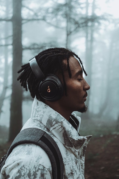 Man Standing With Eyes Closed Listening To Headphones