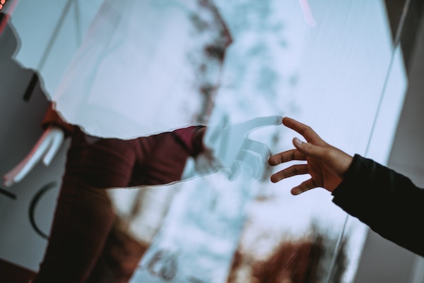 Person Pointing At Reflection In Mirror